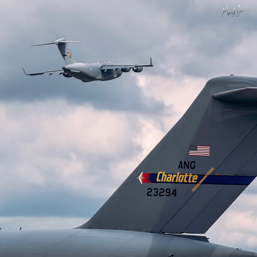 C-17 Globemaster flyover framed by Charlotte Air National Guard tail section — military aviation photography by Michael Komorous