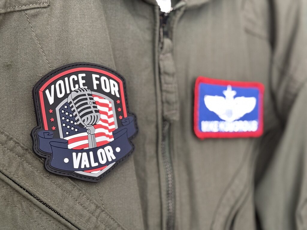 Voice for Valor morale patch on military flight suit — veteran podcast brand