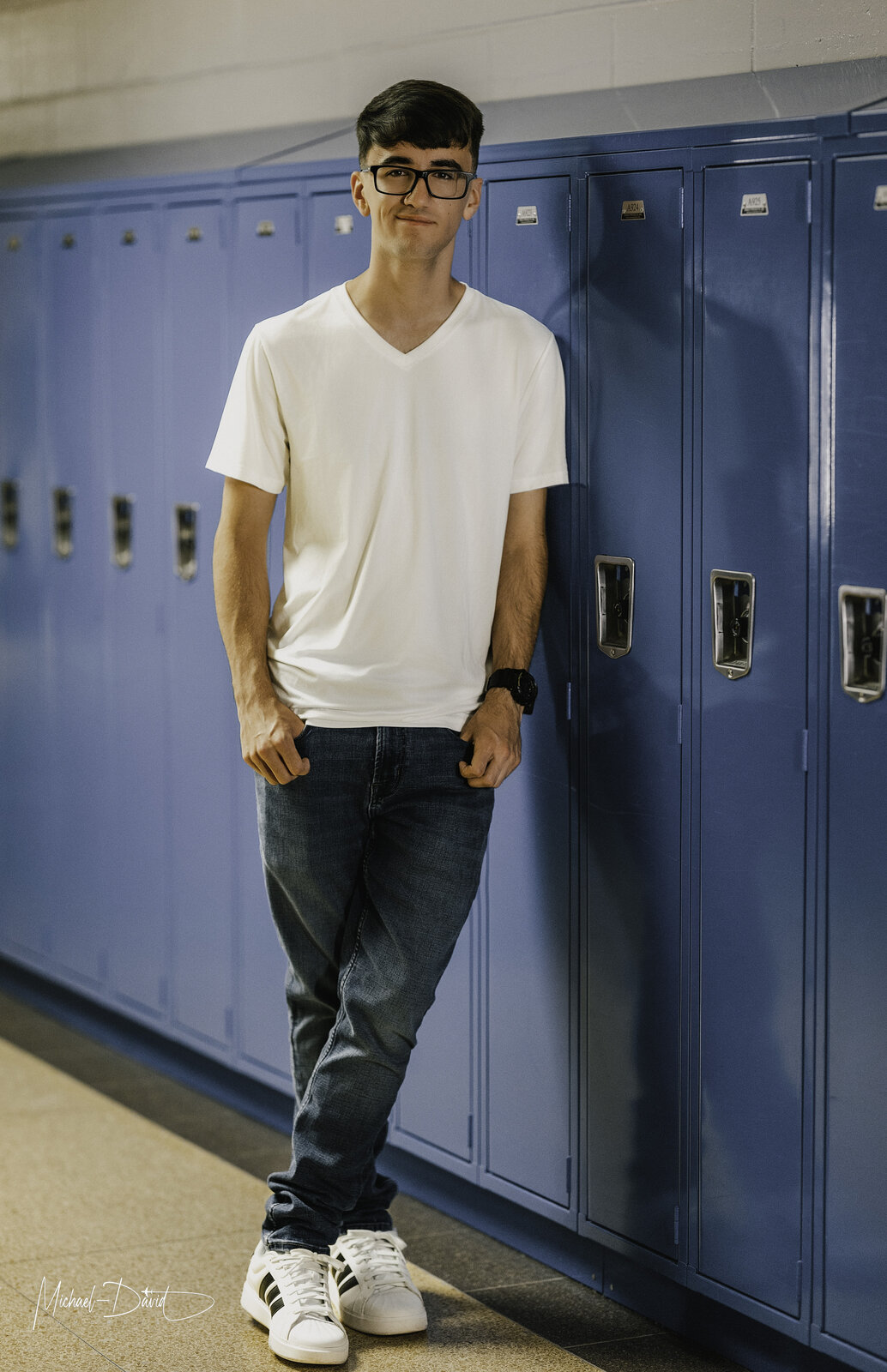 Zach standing full-length by the blue lockers
