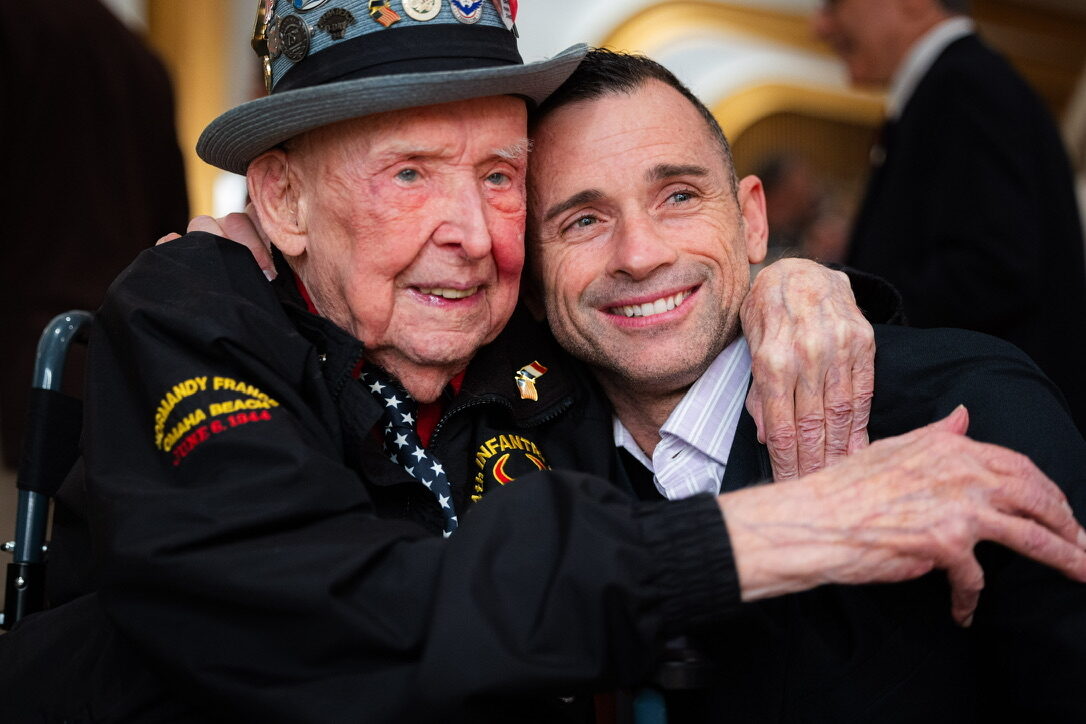 Michael Komorous embraces a D-Day veteran who landed at Omaha Beach with the 1st Infantry Division.
