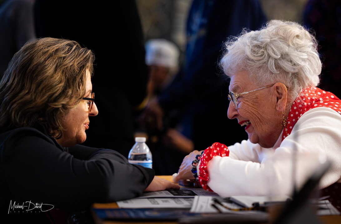 A World War II 'Rosie the Riveter' shares a quiet moment with a guest at the American Veterans Center.