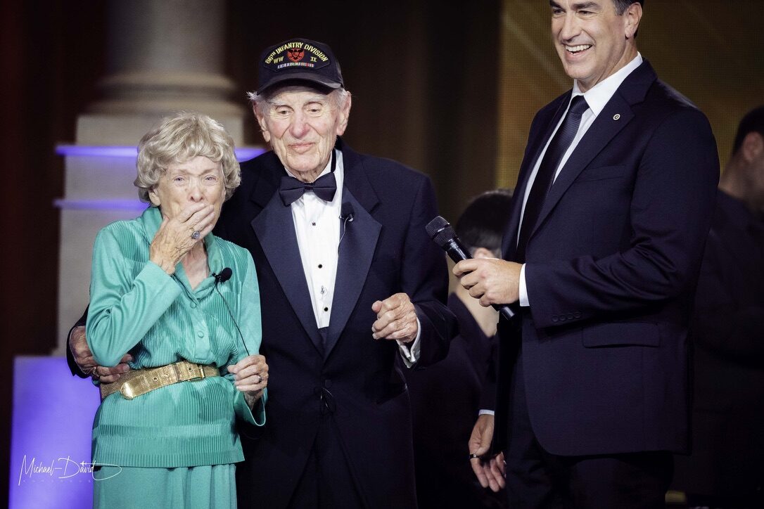 A World War II veteran of the 66th Infantry Division and his wife are interviewed on stage at the American Valor gala.
