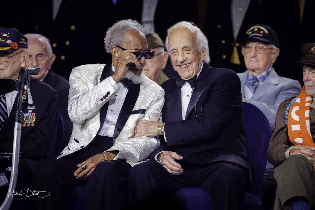 Two World War II veterans share a laugh on stage at the American Valor gala.