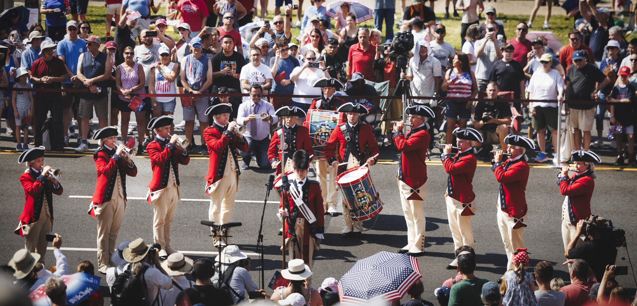 A fife-and-drum corps in Revolutionary War-era uniform performs along the National Independence Day Parade route in Washington, D.C.