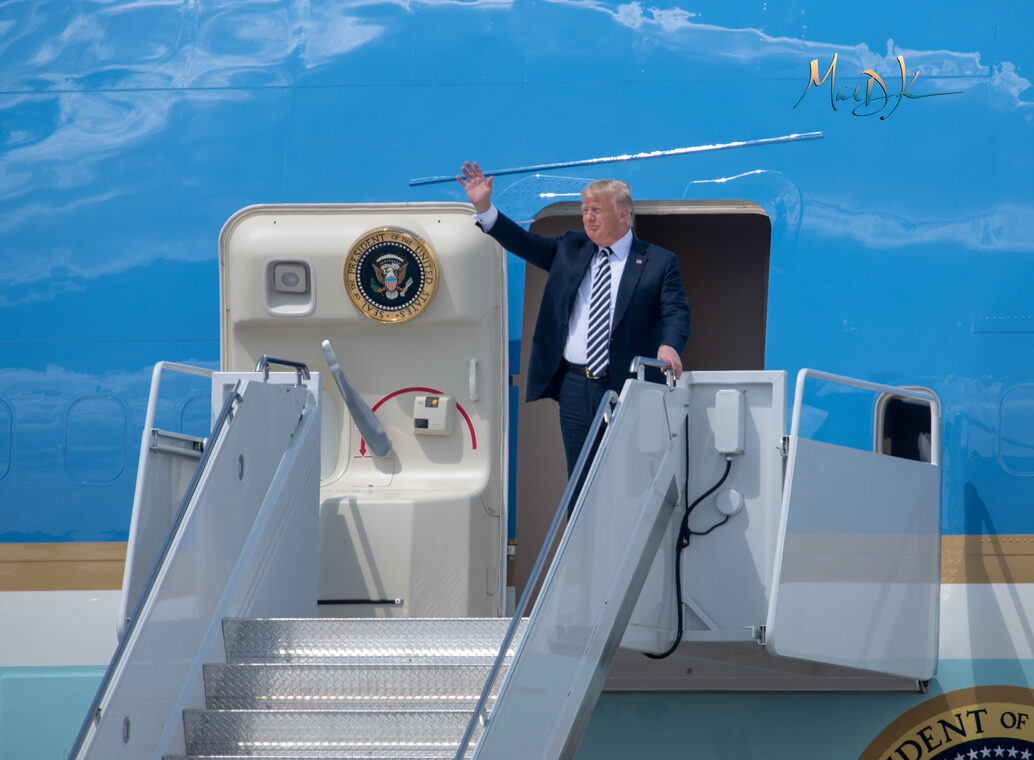 President Donald Trump waves from the door of Air Force One after landing in Charlotte, North Carolina.