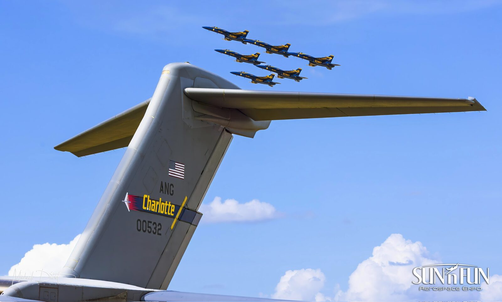 The U.S. Navy Blue Angels in formation above the tail of an Air National Guard C-17 at the Sun 'n Fun Aerospace Expo.